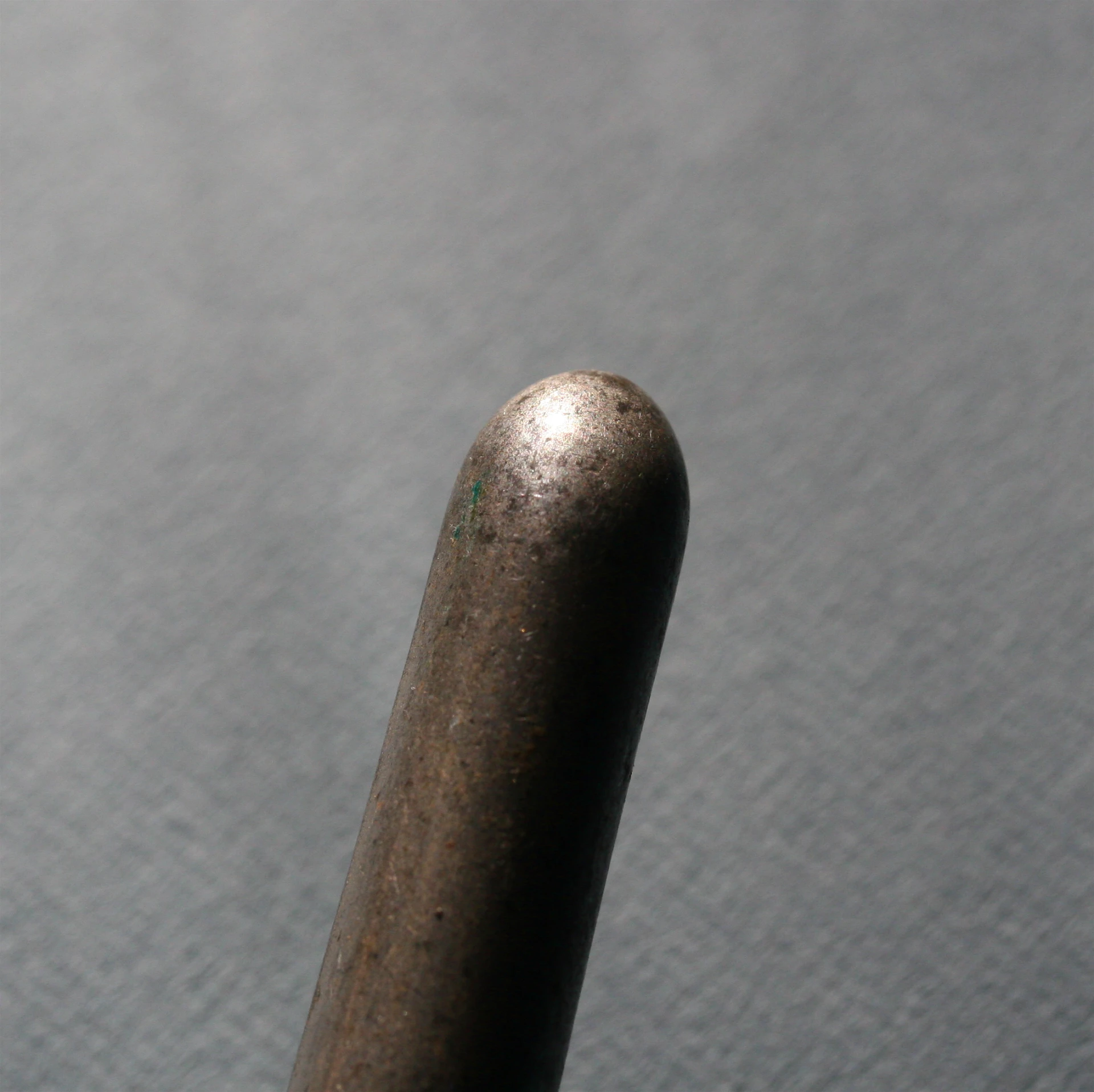 a brown metal object sitting on top of a grey surface