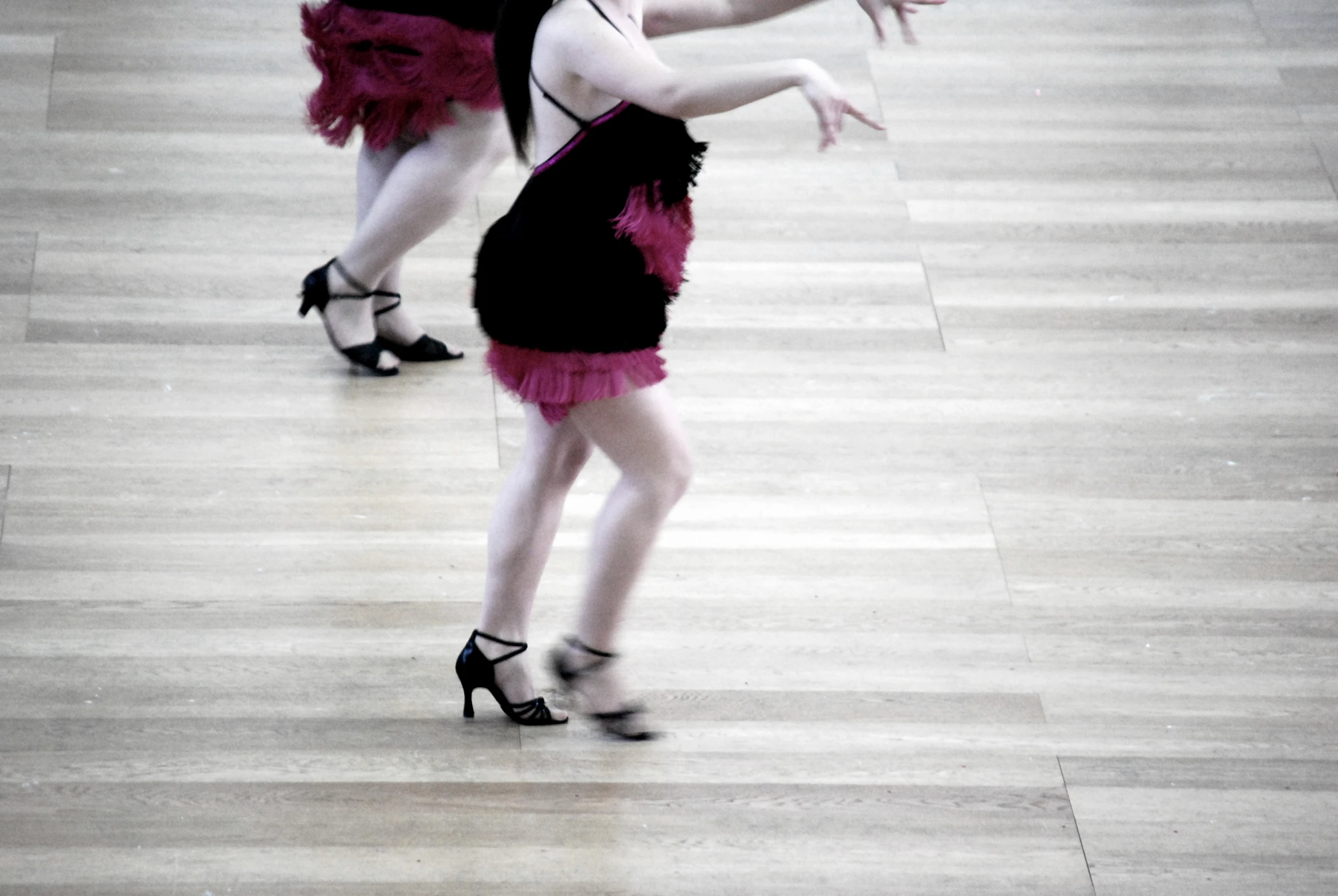 two women are dressed in gats and garb dancing on a hardwood floor