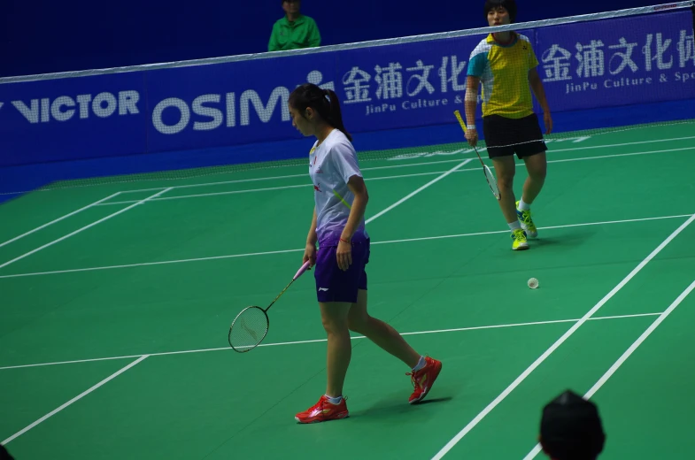 two people on a tennis court holding racquets