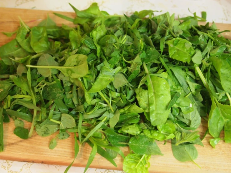 a wooden  board with leaves and basil