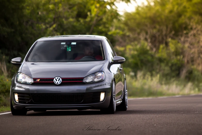 the front view of a gray volkswagen on the road