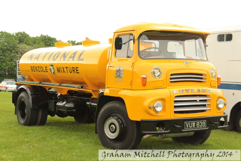 a yellow truck that is on some grass