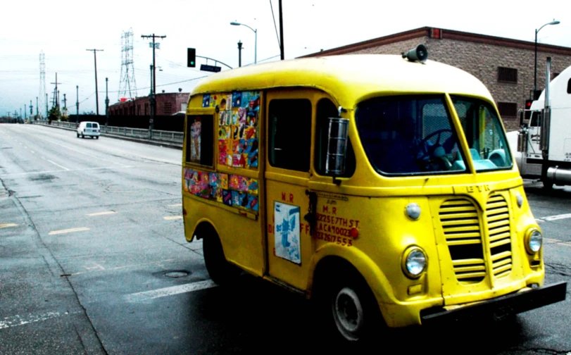 the yellow food truck is parked near a street