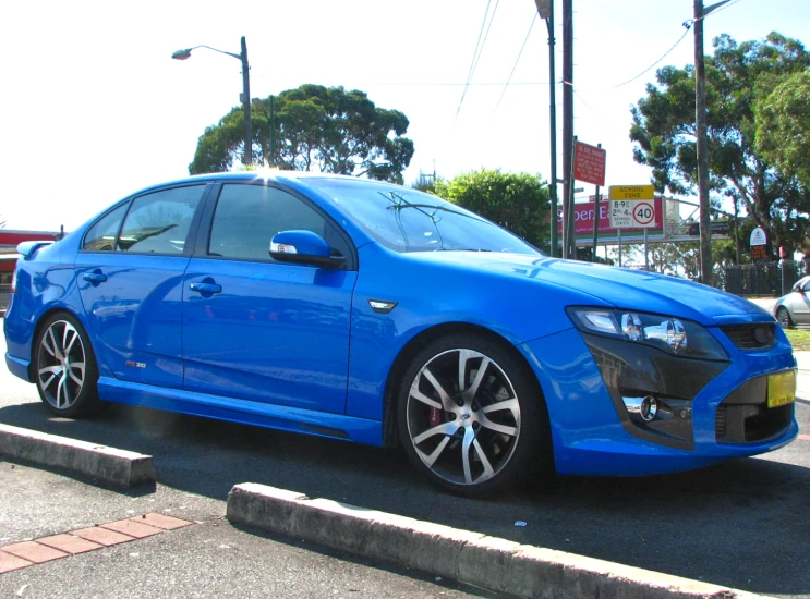 a blue car that is parked in the street