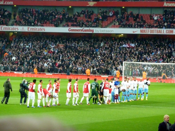 some people are standing in a row on a soccer field