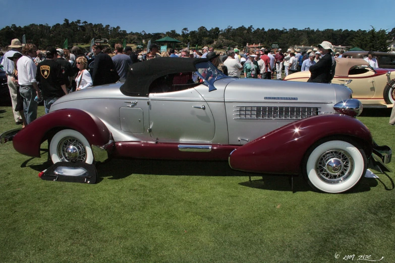 a silver car parked on top of a lush green field