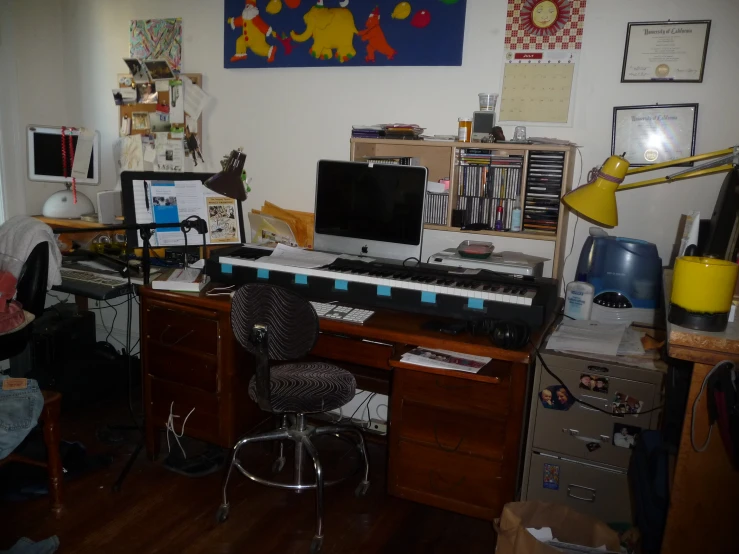 a cluttered bedroom area with desk, computer and other items