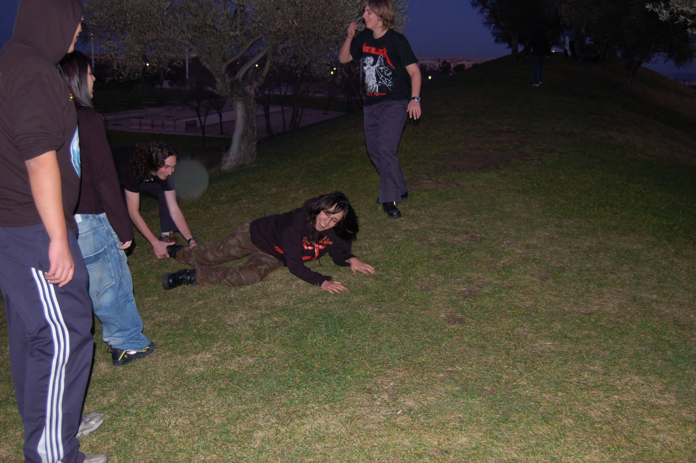 there are three people standing and laying on the grass