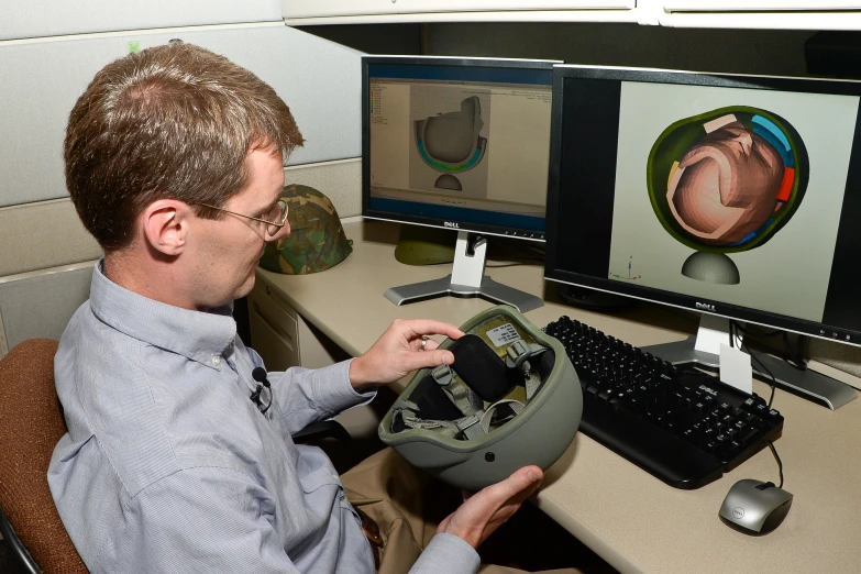 a man looking at soing while sitting at his desk