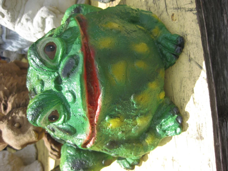 a green ceramic frog sitting on top of a table