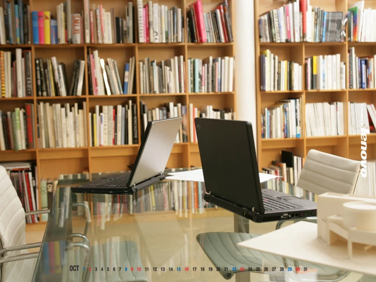 there is a glass table with two laptop computers sitting on it