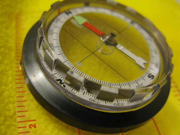 there is an upside down compass on top of a ruler