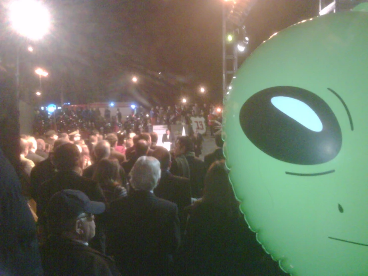 crowd in the street, looking at an alien balloon