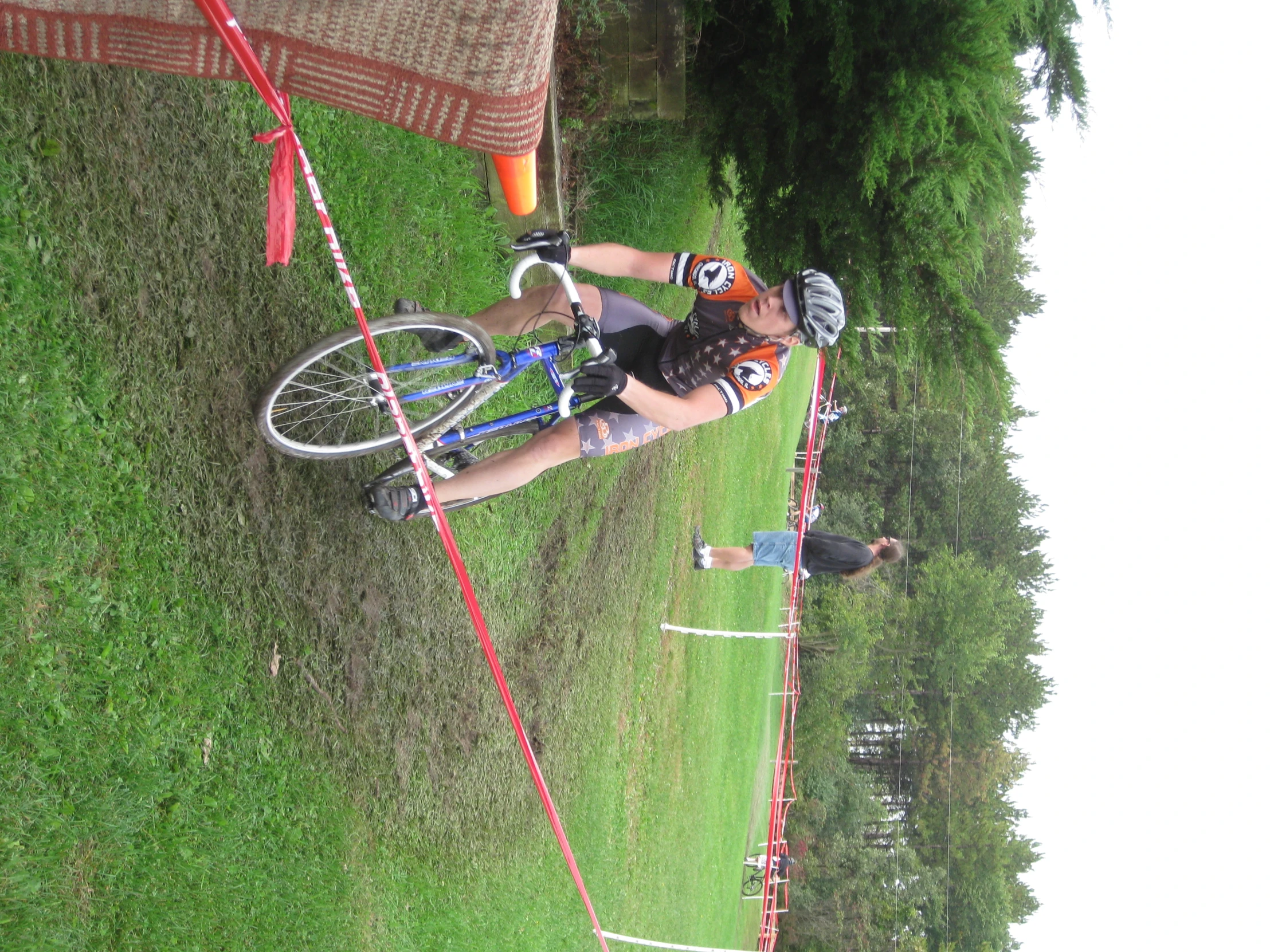 a man is riding his bicycle while others stand behind him