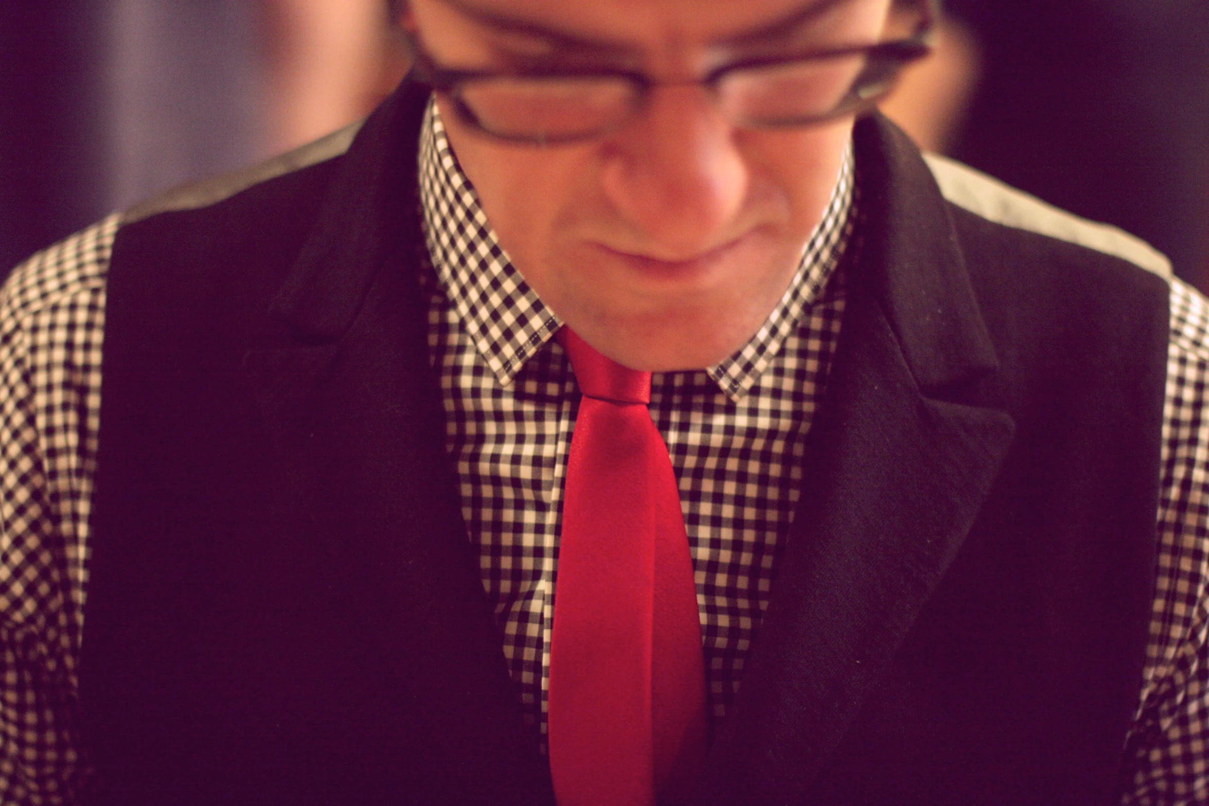 a man wearing glasses and a red tie