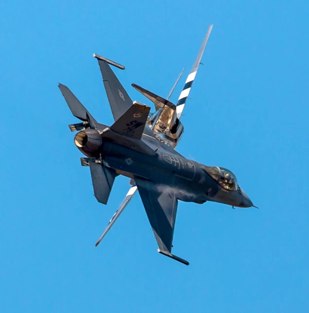 a jet fighter with its door open flying in the sky