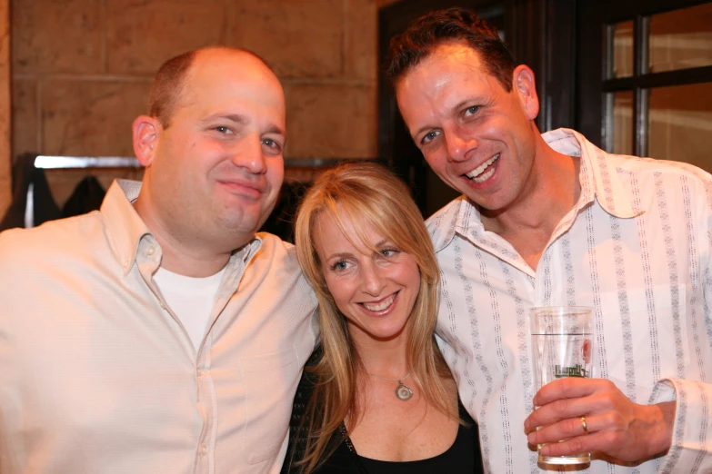 three men and a woman at an event posing for the camera