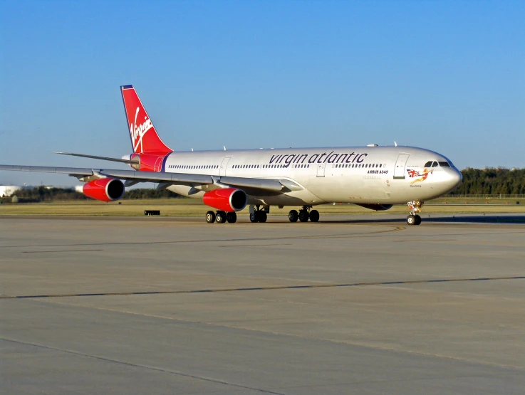 a commercial airplane on the runway, in front of a clear blue sky