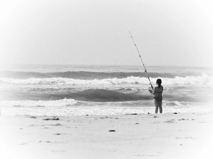 a man is fishing on the beach by the ocean