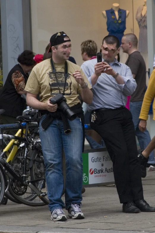 two men standing on the street and using their cell phones