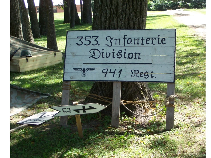 an upside down white sign sits in front of some trees