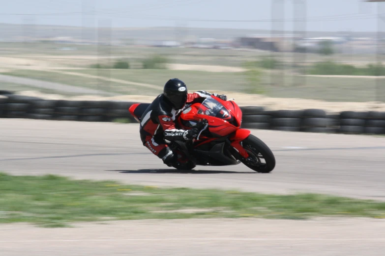 a man in red racing outfit leaning into the back wheel