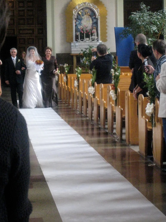 a bride and groom walking down the aisle