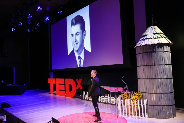 a person standing on stage with an advertit