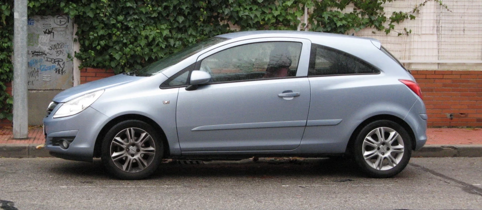 a small silver car is parked on the street