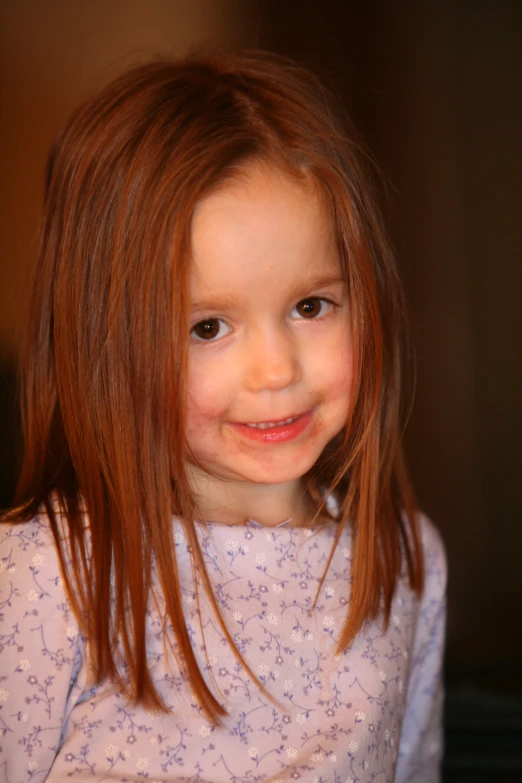 a  wearing a pink shirt has her hair dyed light brown