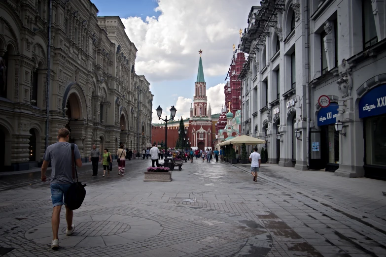 a street with people and cars on a cloudy day