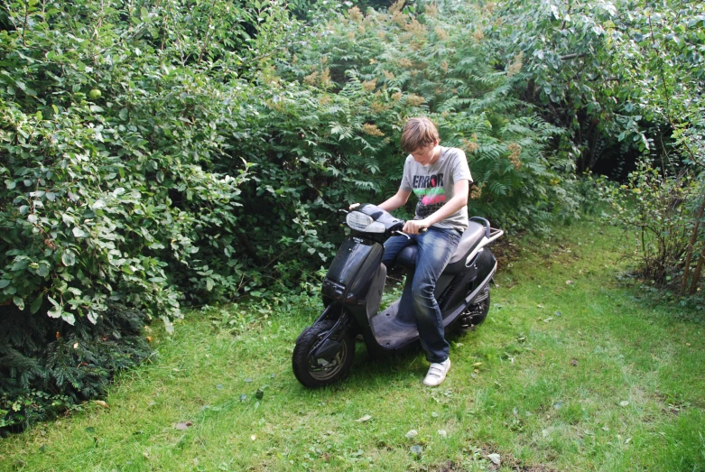 a woman on a moped sits in the middle of bushes