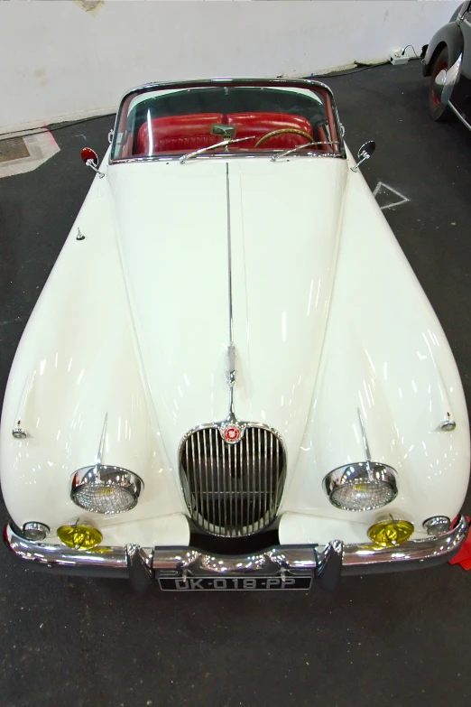 an old model classic white car parked in a garage