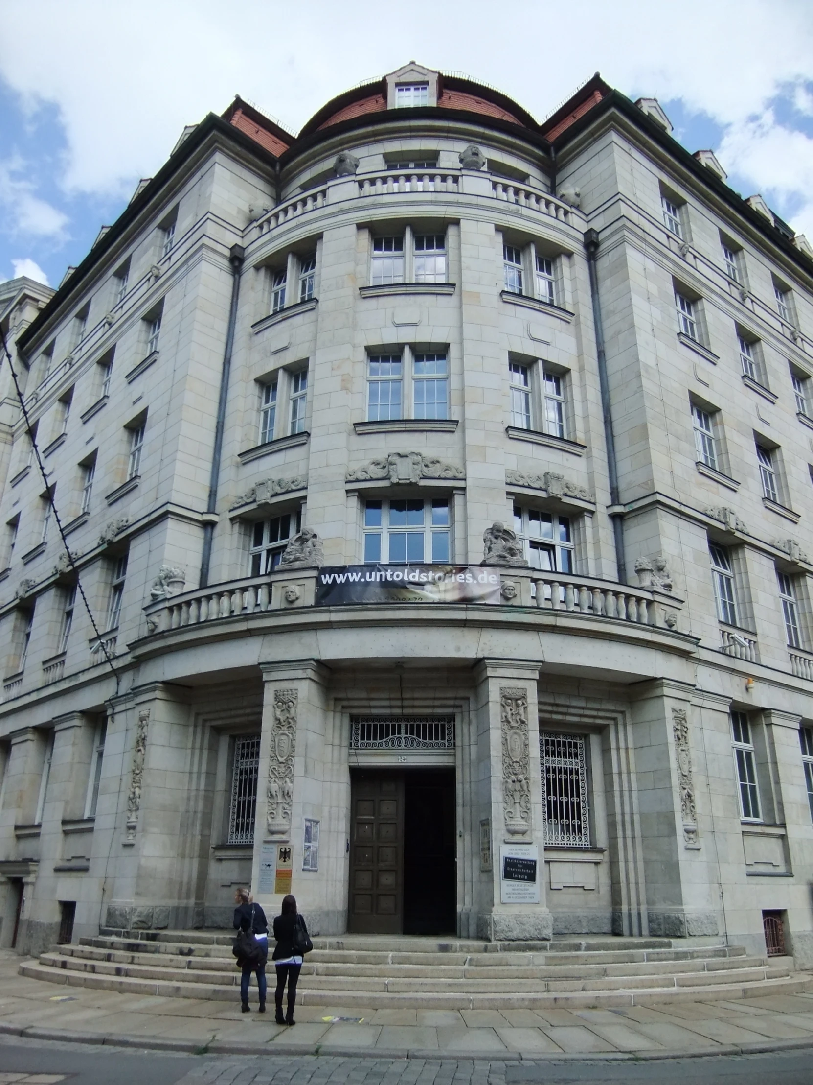 two people stand in front of an ornate building