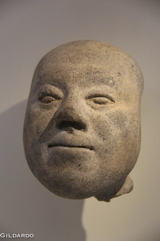 a statue made of stone with a big face