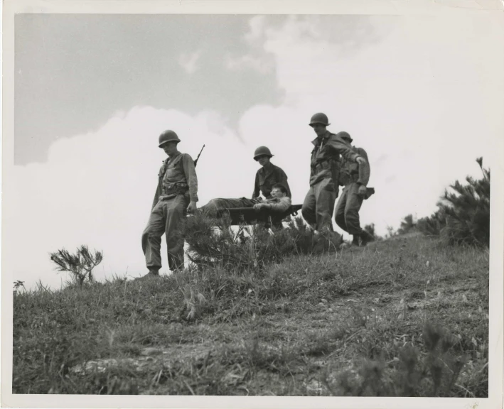 men standing and sitting on a hill with their guns in their hands