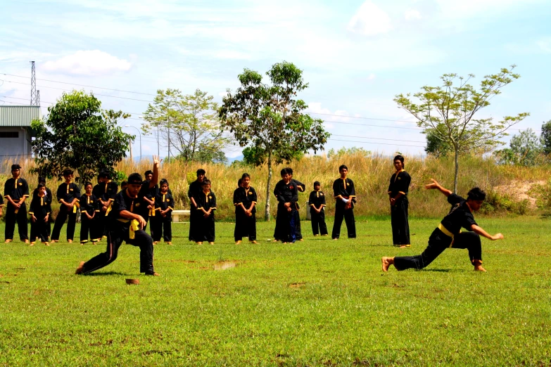 group of people standing and playing in a field