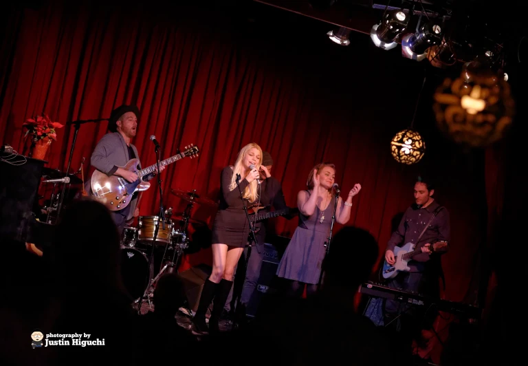 a band on stage singing to a group of people