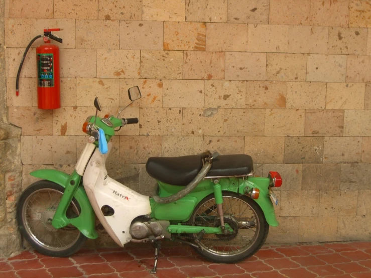 a green scooter and a red fire hydrant