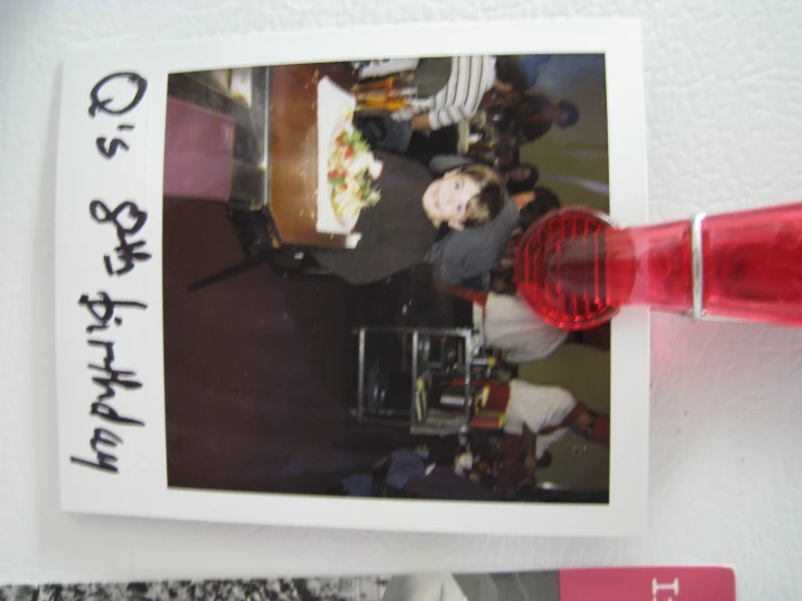 a  sitting in front of a birthday cake