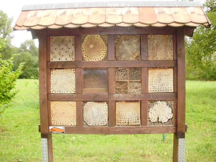 an information stand with bees on it in the grass