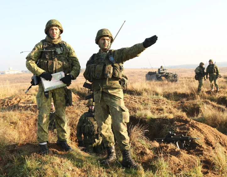 two men wearing camouflage holding weapons in a field