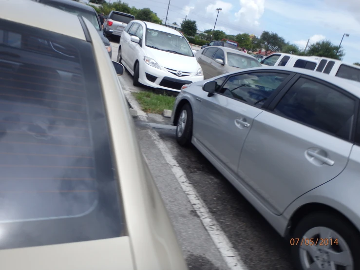 two white cars in parking space next to trees