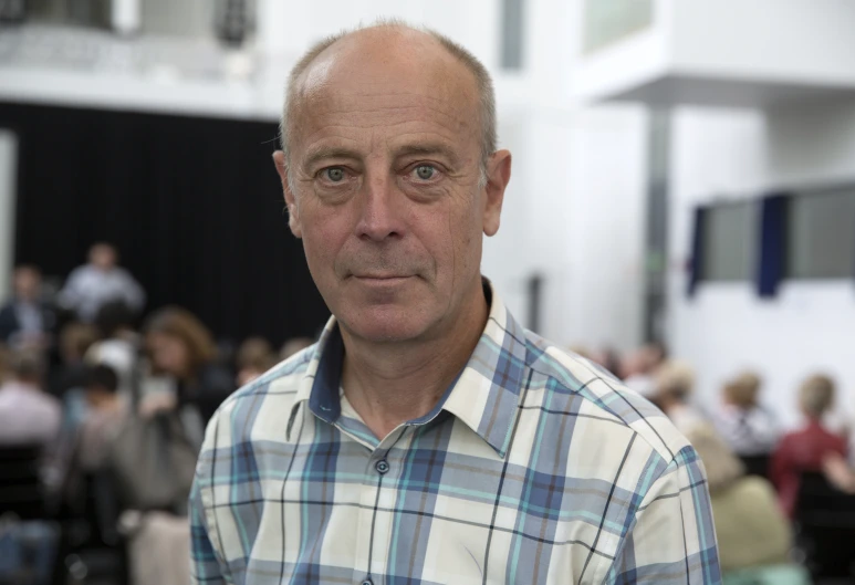 a man in plaid shirt looking into camera