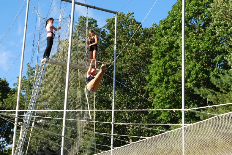 people walking on a rope bridge in an enclosure