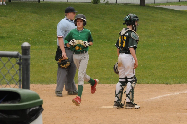 a baseball game with players in uniforms standing at home plate