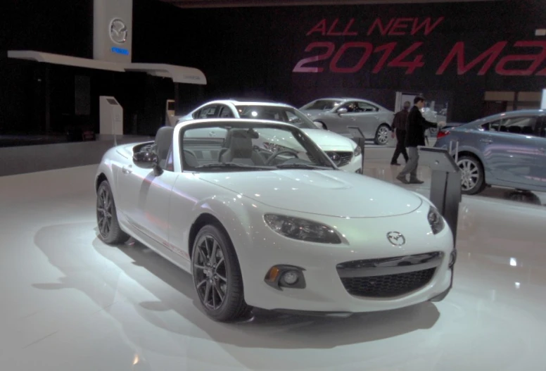 a white car is sitting on display with other cars