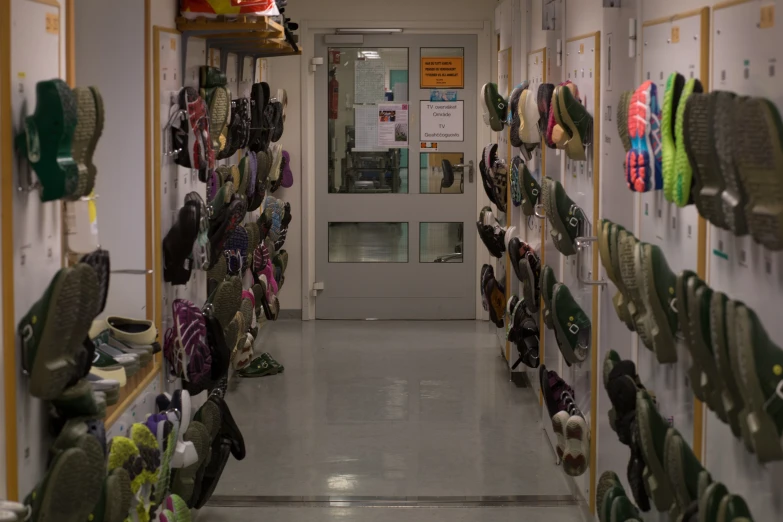 some shoes and sneakers lined up along a wall in a school