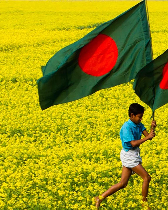 a man running in a field with two large flags