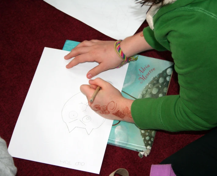 a child drawing a cartoon elephant with a pencil